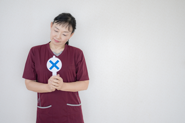 ×印を持ったスタッフ