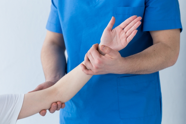 腕の様子を確認するスタッフ