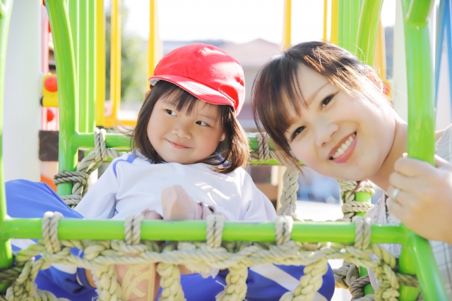 園庭で遊ぶ園児と保育士