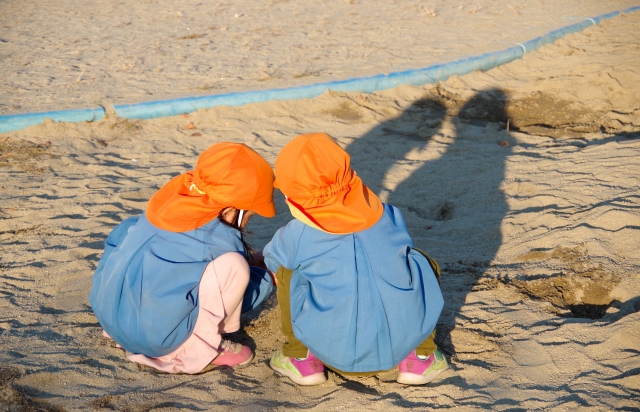 砂遊びをする園児