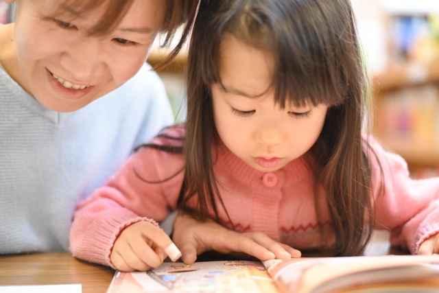 絵本を読む女の子と女性