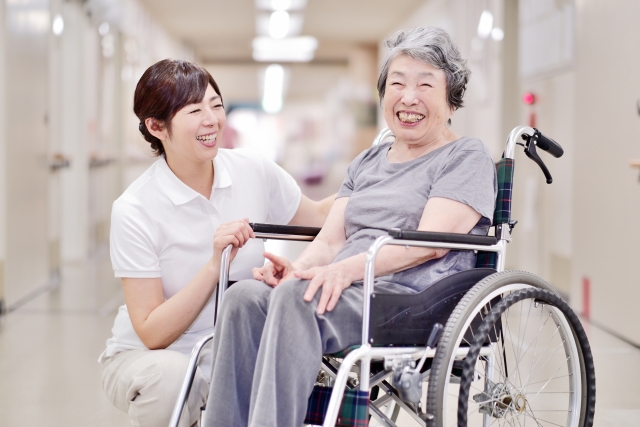 笑顔の車椅子の女性と看護師