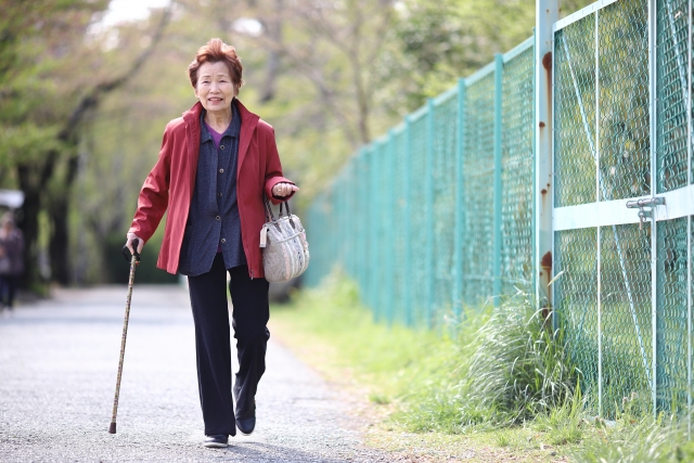屋外で歩く高齢女性
