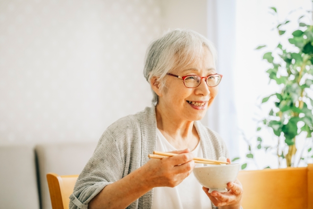 笑顔で食事をする高齢女性